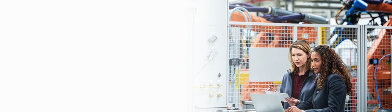 Two manufacturing staff examine data on a device