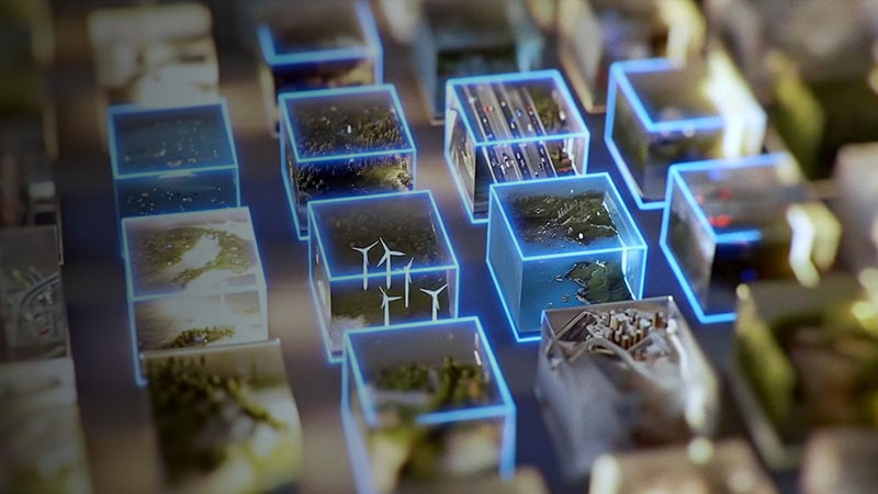 Une grille de cubes numériques lumineux contenant des scènes miniatures d’éoliennes, de villes et de nature.