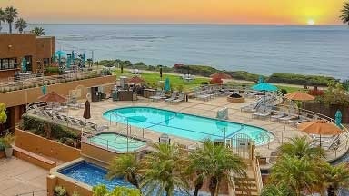 View of a hotel pool and lounge area overlooking the ocean