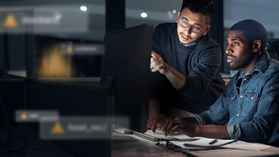 two men looking at a monitor together with Distributed Exploit Protection Recommendation text over image