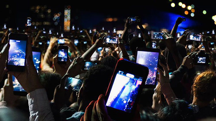 Attendees at an event video on their phones